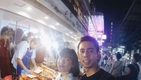 Kalau ini, saat presenter berusia 30 tahun dan suaminya liburan ke Thailand.  Mereka terlihat sedang membeli udang goreng di kedai pinggir jalan.  Foto: Instagram Fitri Tropica