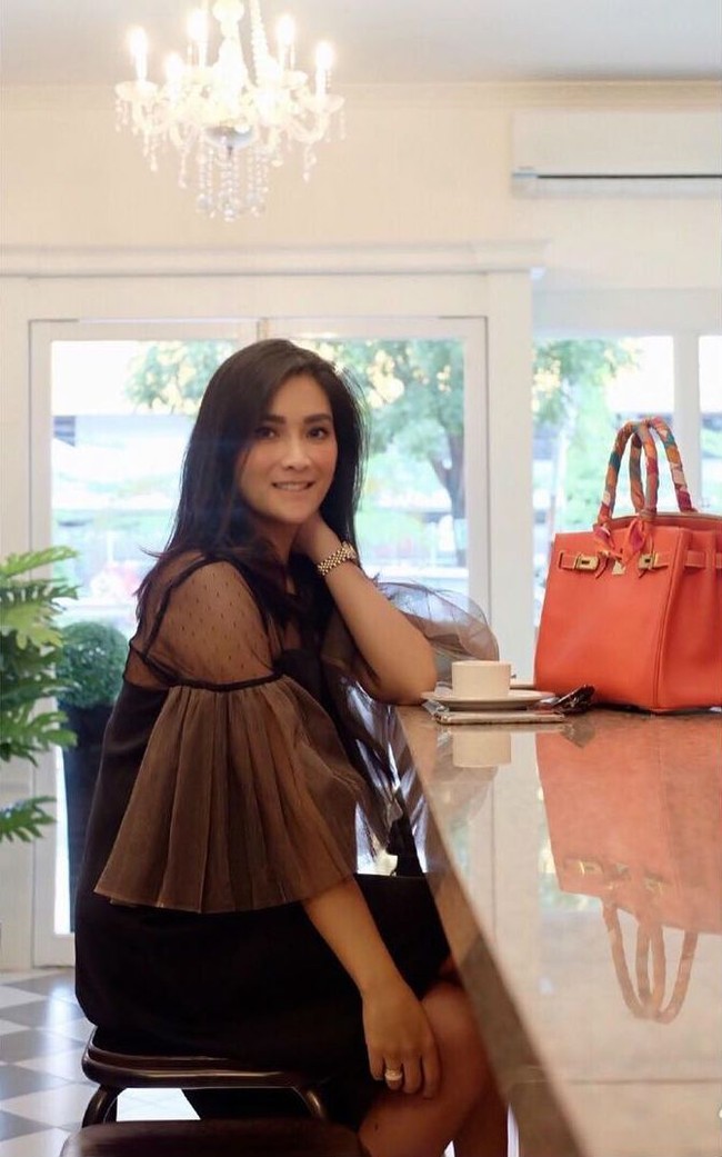 Pengusaha kue Rozma Suhardi berpose bersama tas Hermes Birkin warna oranye seharga Rp 200 jutaan. Foto: Instagram