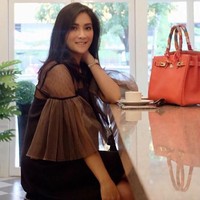 Pengusaha kue Rozma Suhardi berpose bersama tas Hermes Birkin warna oranye seharga Rp 200 jutaan. Foto: Instagram