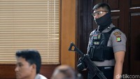 Polisi bersenjata berjaga di ruang sidang. Tujuannya untuk menjaga situasi agar tetap kondusif.