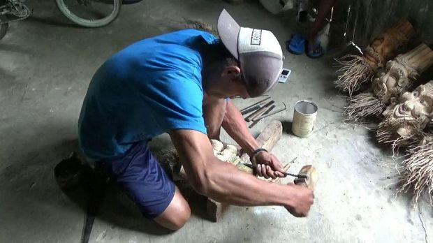 Soim sedang memahat bonggol bambu.