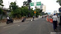 Petugas menggunakan pengeras suara untuk mengerahkan pengendara mobil dan pemotor ke arah flyover (Foto: Seysha Desnikia/detikcom)