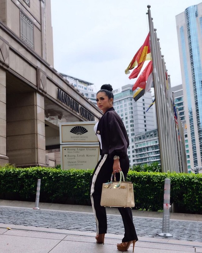 Berkunjung ke Kuala Lumpur, Malaysia, Krisdayanti berpose di depan Hotel Mandarin Oriental sambil membawa tas Hermes Birkin Ostrich Parchemin Gold Hardware seharga US$ 37.250 atau sekitar Rp 497 juta. Foto: Dok. Instagram Krisdayanti