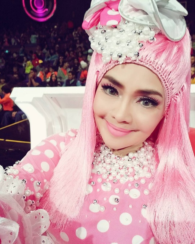 Penyanyi Iyeth Bustami tampil serba pink dengan hijab dipadukan helaian benang yang disebut netizen mirip kemoceng. Foto: Instagram