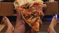 Menikmati pizza sambil nonton jadi salah satu ritual bersantai bapak satu anak ini. Foto: Instagram @riodewanto