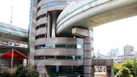 Terdapat tiang penyangga untuk menahan beban jalan tol. Jika diperhatikan, gedung Gate Tower itu terlihat sebagai terowongan. Istimewa/Forbes.