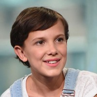 Kesan tomboi tak lepas dari Millie Bobby Brown. Rambut pendeknya yang keriting hanya ditata simpel. Foto: Getty Images