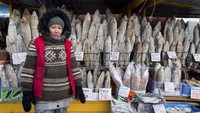 Ikan-ikan yang dijual pun sudah langsung membeku tanpa perlu disimpan di lemari es. Wanita pedagang ikan ini pun terlihat membalut tubuhnya dengan pakaian tebal dan berlapis. (Foto: Vera Salnitskaya/The Siberian Times)