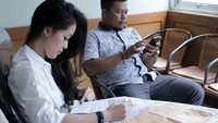 Gracia tampak serius membaca suatu berkas.