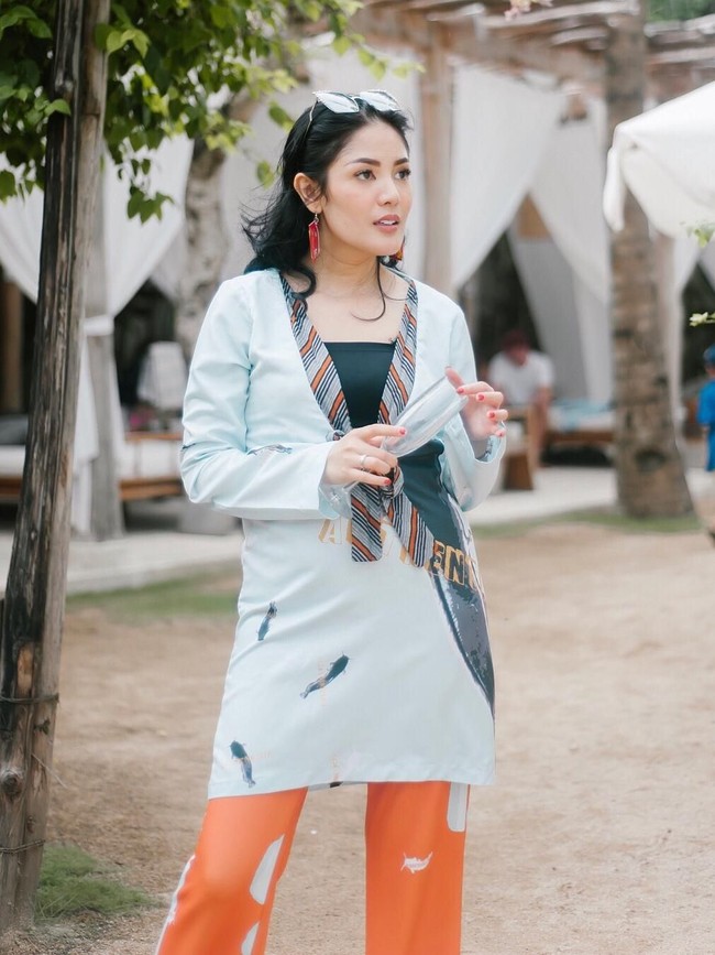 Antignya menjadi penemanis dress biru bermotif ikan lele dan celana oranye bergaya cut-bray. Adapun stylist atau penata gaya Erich Al Amin yang berada di balik penampilan unik Nindy unik ini. (Foto: Instagram/Nindy Ayunda)