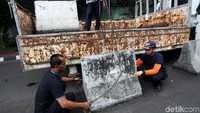 Beton diangkat ke atas truk menggunakan tali sling.