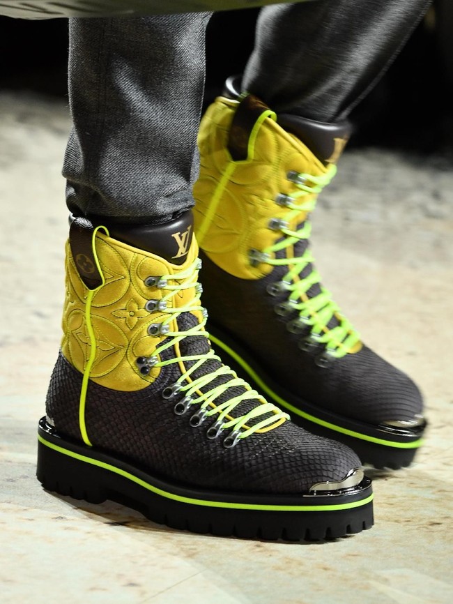 Selain bermotif kulit hewan, hadir pula boots dengan sapuan warna yang lebih berani seperti kuning dan hijau neon. (Foto: Pascal Le Segretain/Getty Images)