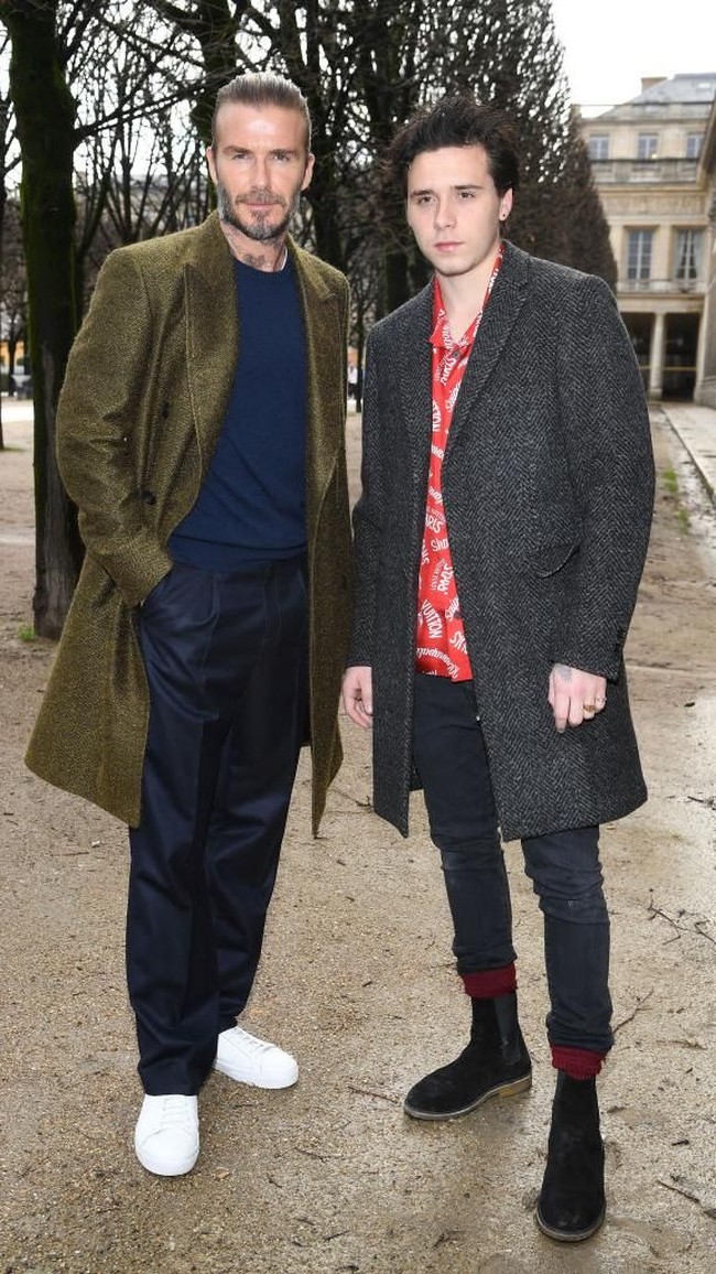 David Beckham dan putra pertamanya, Brooklyn, saat menghadiri fashion show Louis Vuitton koleksi Menswear Fall/Winter 2018-2019 di Paris Fashion Week Januari lalu. Keduanya modis dalam balutan coat gelap. (Foto: Getty Images)
