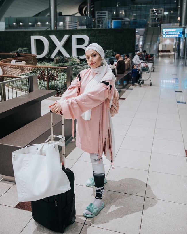 Gaya airport Haifa Basseiso tetap chic dengan kaos longgar warna pink dipadukan dengan legging dan tas ransel berwarna senada. Foto: Instagram