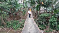 Jembatan gantung itu dialasi oleh seng dan ditopang kayu. (Kanavino-detikcom)