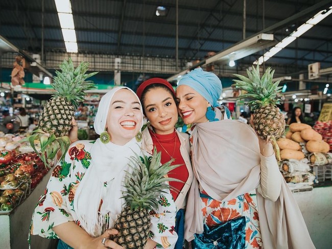 Beralih ke Thailand, tampilan Haifa pun jadi lebih tropikal. Ia memakai warna-warna terang, jadi lebih serasi ya sama nanas yang ia pegang? Foto: Instagram