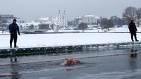 Air es dan salju tebal tak menghalangi para peserta ini untuk berenang dan jadi yang tercepat. Mereka berenang di aliran Sungai Svisloch yang membeku (Vasily Fedosenko/Reuters)