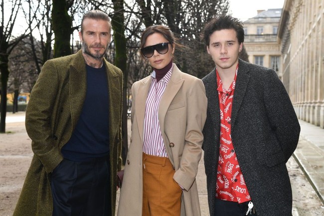 Family goals! David, Victoria dan Brooklyn berpose bersama sebelum memasuki area fashion show Louis Vuitton di Paris Fashion Week. Foto: Getty Images