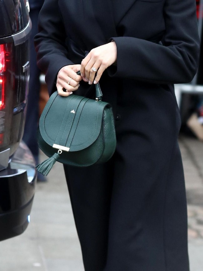 Tidak ketinggalan tas De Mellier London yang dipermanis dengan aksen fringe. Warna hijau zamrudnya seolah menghidupkan gaya busananya yang bernuansa gelap. (Foto: Getty Images)