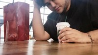Berlatarkan ruang tunggu bandara, Igun terlihat menyeruput segelas kopi hangat sambil menunggu pesawat yang akan ditumpanginya. Ini adalah perjalanan Igun menuju Makassar untuk promo produk hijab terbarunya. Foto: Instagram @ivan_gunawan