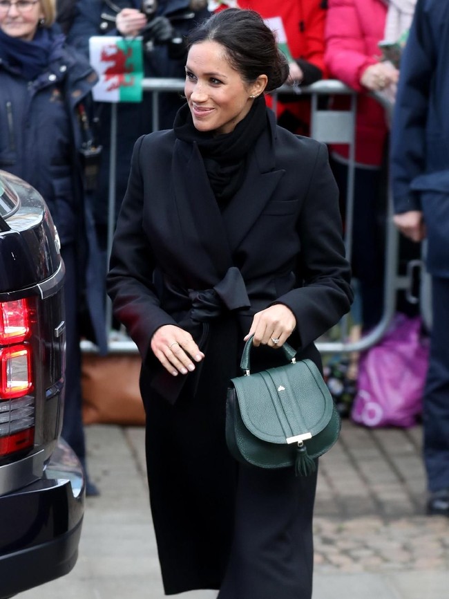 Struktur mantel yang maskulin ditambah dengan sabuk berbentuk pita yang manis semakin mempertegas pernyataan gaya Meghan yang modis. (Foto: Getty Images)