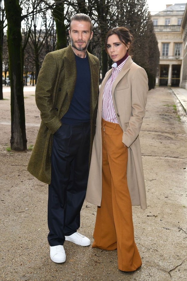 Seperti biasanya, Victoria Beckham memilih gaya chic ala Londoners dengan padu padan kemeja di atas turtle neck, celana lebar dan coat panjang. Foto: Getty Images