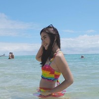 Mengenakan bikini two pieces berwarna pelangi ketika tengah di pantai, Sinta juga tampil memesona. Foto: Instagram