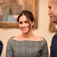 Berada di dalam ruangan, Meghan Markle membuka mantel tersebut dan terungkaplah blus abu-abu bermotif kotak-kotak sebagai atasan. Garis leher model bateau neck atau sabrina mengekspos bahu Meghan yang indah. (Foto: Getty Images)