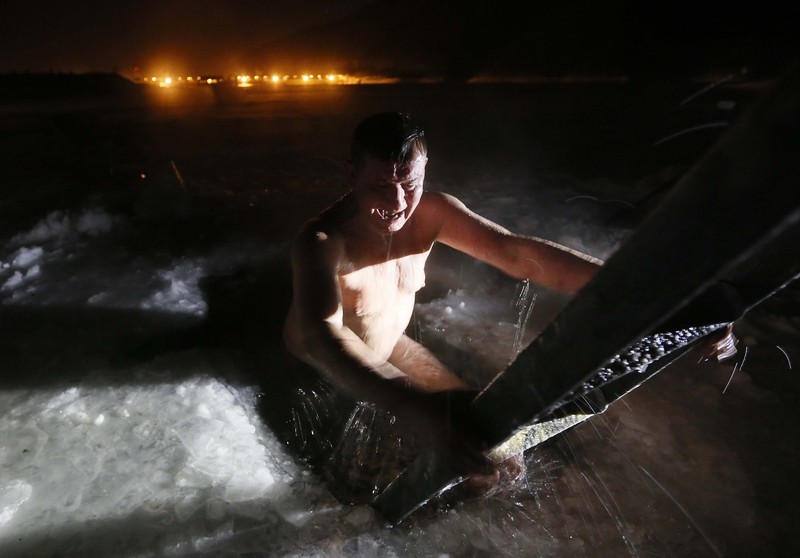 A man reacts after taking a dip in the icy waters of the Yenisei River during Orthodox Epiphany celebrations, with the air temperature at about minus 36 degrees Celsius (minus 32.8 degrees Fahrenheit), outside Krasnoyarsk, Russia January 19, 2018. REUTERS/Ilya Naymushin