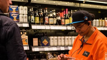Walau tanpa kasir, Amazon Go tetap perlu karyawan. Terutama untuk melakukan pemeriksaan identitas bagi pelanggan yang hendak membeli wine dan bir di dalamnya. (Foto: The New York Times/Kyle Johnson)