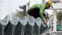Mereka membersihkan lumut di dinding air mancur.