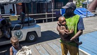 Warga menggendong anaknya sebelum pemeriksaan kesehatan di Rumah Sakit Umum Daerah (RSUD) Agats, Kabupaten Asmat, Papua, Senin (22/1). Foto: AntaraFOTO/Agung Rajasa