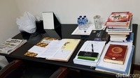 Minuman mineral kemasan dan Alquran juga berada di meja kerjanya.