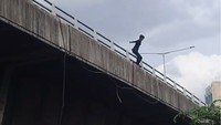 Awalnya dia di sana diteriakin. Terus dia lari ke sini terus diteriakin weh, weh, jangan loncat, gitu. Terus di sini dia sempet duduk dulu, baru loncat, ujar Mulyani, warga lainnya. (Foto: Screenshot video)