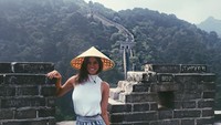Ketika liburan, Gerogia pun gemar berfoto layaknya lokal. Ini fotonya dengan topi caping saat liburan ke Tembok Besar China (@georgia.nielsen/Instagram)