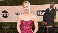 Saat red carpet, ia tampil anggun dengan dress merah yang memamerkan bahu seksinya. Alberto E. Rodriguez/Getty Images.