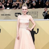 Aksen berkilauan seolah jadi tema atau tren busana di SAG Awards 2018. Salah satu aktris yang juga mengenakan baju berkilauan adalah Dakota Fanning. Ia memakai gaun keluaran Prada yang juga penuh sequin. Foto: Getty Images