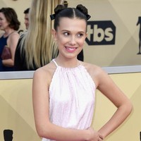 Rambut yang disanggul dua dengan tambahan pita, membuat gaya Millie terkesan playful. Sesuai untuk usianya yang masih 13 tahun. Foto: Getty Images