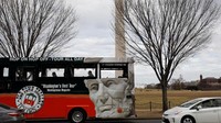 Sebuah tur bus melintas di dekat Monumen Washington. Terlihat penumpang di dalamnya tidak banyak. Foto: REUTERS/Yuri Gripas