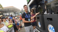Petenis Australia, Thanasi Kokkinakis, menyempatkan diri bermain video game AO di garden square Melbourne Park pada Australia Terbuka 2018. (Vince Caligiuri/Getty Images)