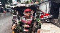 Abdul bergaya di atas becaknya.