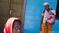Seorang ibu bersama anaknya dari kampung Warse, Distrik Jetsy menunggu ambulan setibanya di pelabuhan Misi, Agats, Kabupaten Asmat, Papua, Senin (22/1). M Agung Rajasa/Antara Foto.