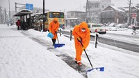 Pekerja kota membersihkan salju tebal yang ada di depan gedung pemerintah daerah di Machida, Tokyo, 22 Januari 2018.  (Foto: Dok. The Mainichi)
