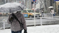 Seorang pria berjalan di jalanan tertutup salju di Nakano Ward, Tokyo, 22 Januari 2018. Kemarin, seperti dilansir Reuters, layanan kereta api setempat terpaksa dibatalkan akibat cuaca buruk. (Foto: Dok. The Mainichi)