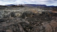 Tanah yang hitam dan tandus terhampar sejauh mata memandang. Aliran lava terlihat di beberapa sudut, dan banyak asap yang keluar dari balik bebatuan (Thinkstock)