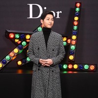 Berpose di backdrop Dior, senyuman manis aktor 32 tahun itu selalu mengembang di bibirnya.  Foto: dok. Getty Images