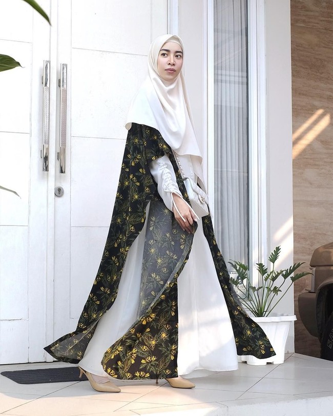 Untuk kamu yang ingin tampil lebih dinamis, kenakan outerwear seperti cape atau vest. Fitri Aulia menambahkan vest panjang bermotif dan memadukannya dengan dress dan hijab putih. Warna netral seperti tampilan Fitri jadi pilihan paling aman untuk menghadiri pengajian. Foto: Instagram