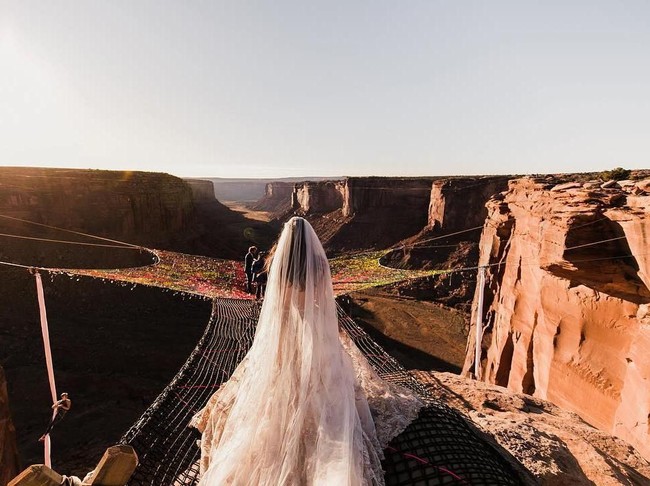 Dikelilingi dengan tebing batu merah yang indah dan sebuah jaring yang terhampar di atas jurang dengan ketinggian 121 meter, pasangan ini mantap melangsungkan pernikahannya pada 20 November lalu. Foto: Instagram @_kimw_