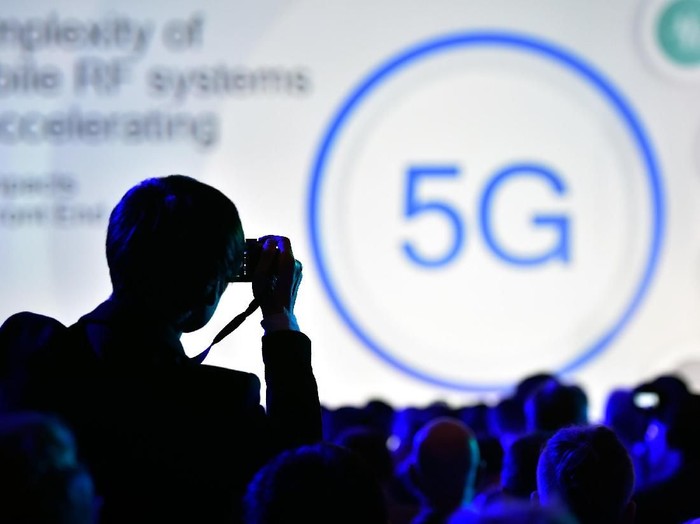 LAS VEGAS, NV - JANUARY 08:  An attendee photographs a 5G logo display during a Qualcomm press event for CES 2018 at the Mandalay Bay Convention Center on January 8, 2018 in Las Vegas, Nevada. CES, the worlds largest annual consumer technology trade show, runs from January 9-12 and features about 3,900 exhibitors showing off their latest products and services to more than 170,000 attendees.  (Photo by David Becker/Getty Images)