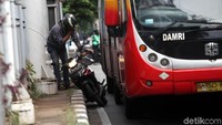 Ia pun terpaksa turun dari motornya.